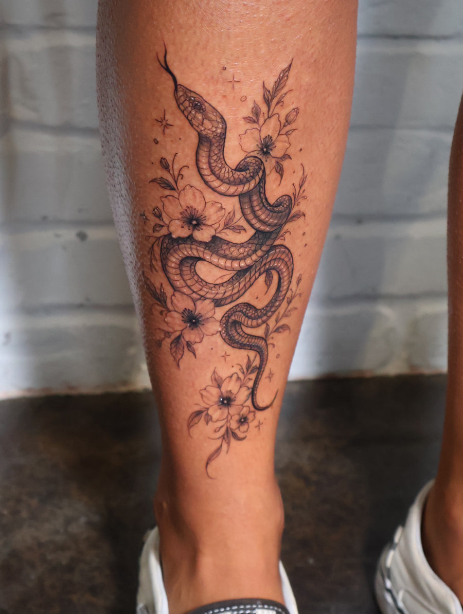 Snake and floral fine line tattoo by Dido