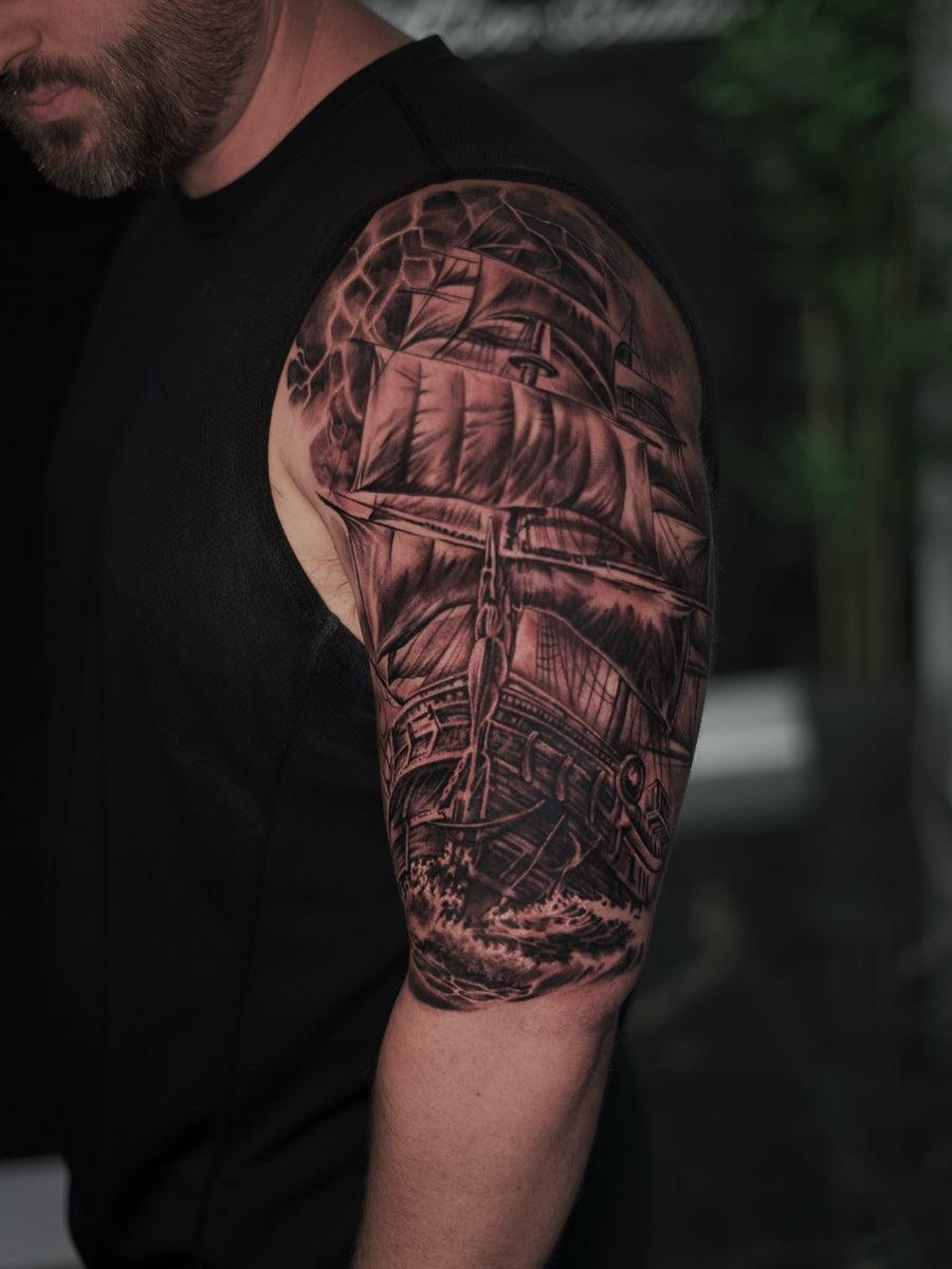 Black and grey ship shoulder tattoo by Terrero